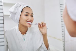 young woman brushing teeth W8UT7RJ 1