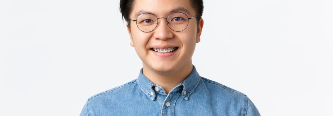 close-up-of-hopeful-cute-asian-guy-with-braces-smi-9EDRS93