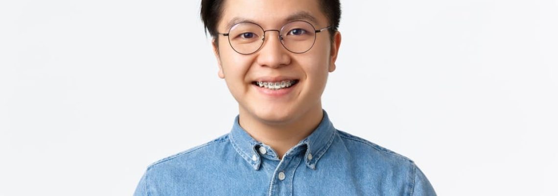 close-up-of-hopeful-cute-asian-guy-with-braces-smi-9EDRS93