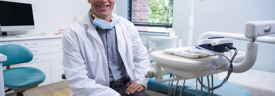 portrait-of-smiling-dentist-sitting-on-chair-76JSMLK (1)