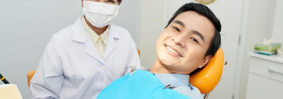 smiling-ethnic-dentist-and-man-in-dental-chair-CNVS7GE (1)